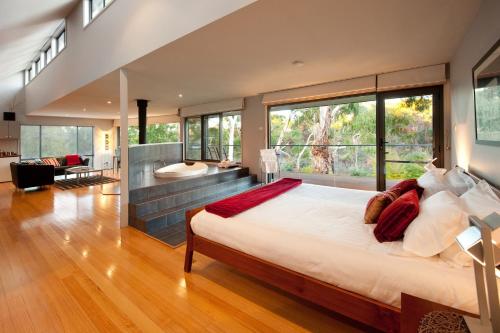 a bedroom with a large bed and a bathroom at Dee Jays Studio in Hepburn Springs