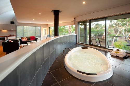 a bathroom with a large bath tub in the middle at Dee Jays Studio in Hepburn Springs