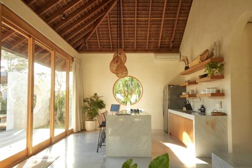 a kitchen with a counter and a large window at Villa Cerah in Uluwatu