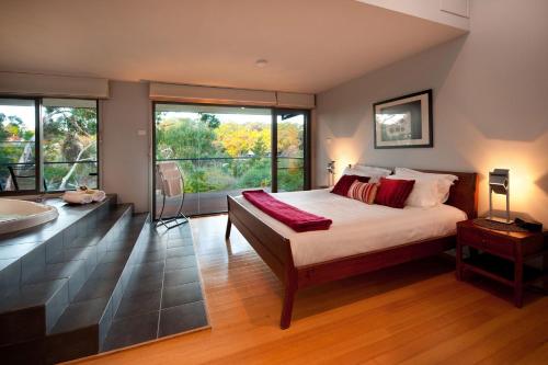 Un dormitorio con una cama, una bañera y un lavabo. en Dee Jays Studio, en Hepburn Springs