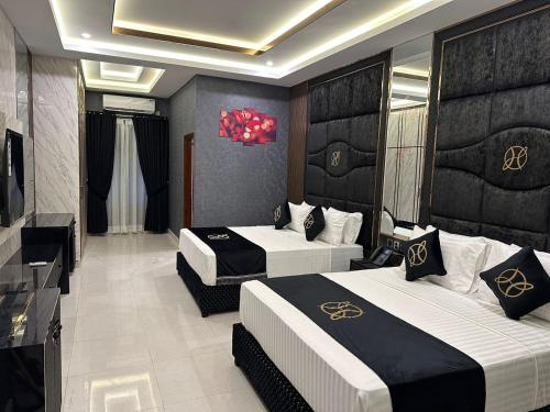 um quarto de hotel com duas camas e uma televisão em The Signature Hotel em Islamabad