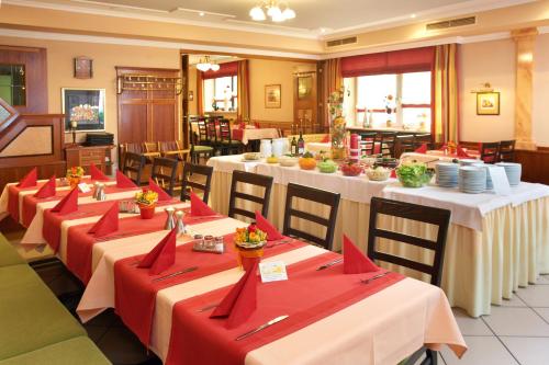 a restaurant with long tables with red napkins on them at Gasthof Gigl in Neustadt an der Donau