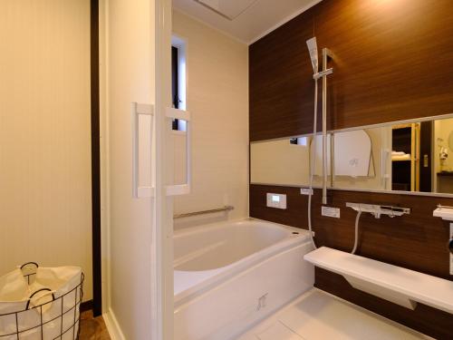a bathroom with a bath tub and a sink at The Sense of Wonder Holistic Glamping in Yufuin
