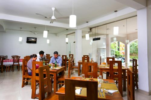 two people sitting at tables in a restaurant at Citrus Cafe & Restaurant in Kandy