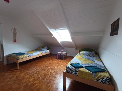 two beds in a attic room with a skylight at La rose de Provins in Provins