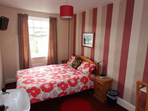 a small bedroom with a bed and a sink at Angel Guesthouse in Tiverton