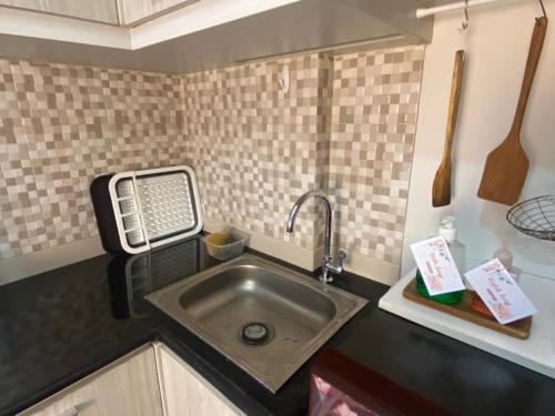 un bancone della cucina con lavandino in cucina di Comfy 2 Bedroom Apartmen Pavilion Permata Surabaya a Dukuhpakis