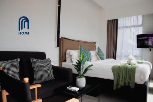 a hotel room with a bed and a couch at Homi Oasis 和逸绿洲 in Kota Kinabalu