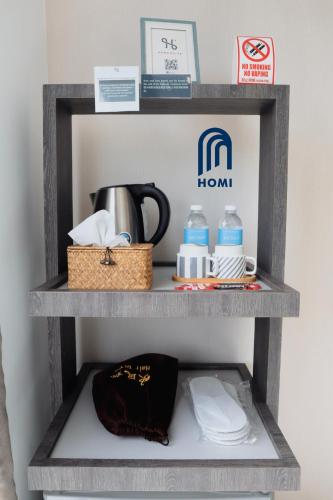 a shelf with towels and water bottles on it at Homi Oasis at KK Times Square 和逸绿洲 in Kota Kinabalu