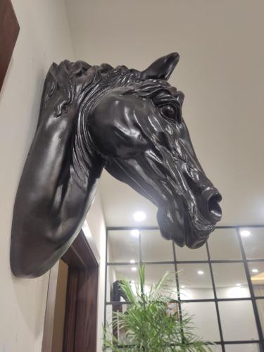 a bronze horse head hanging from a wall at Eiffel Tower Apartment in Rawalpindi