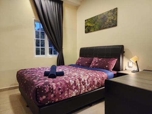 a bedroom with a bed with a purple comforter at Fathers Guesthouse Age 7 years old and above only in Tanah Rata