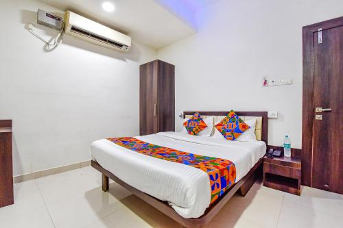 a bedroom with a large white bed with colorful sheets at Hotel Vandana Palace in Kota