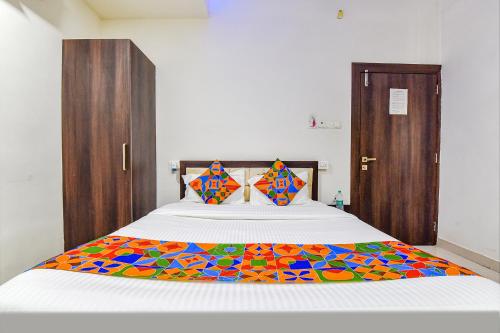 a bedroom with a bed with a colorful blanket on it at Hotel Vandana Palace in Kota