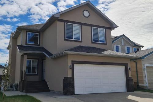a house with a garage door in front of it at Spacious comfortable Air-Conditioned. Near airport! in Calgary