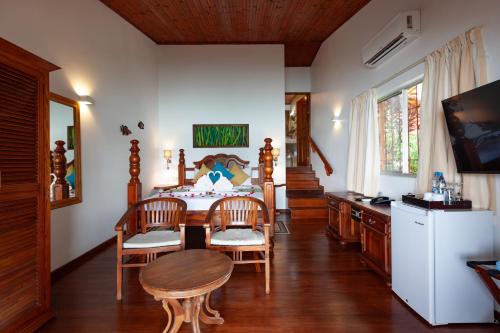 Una cocina con mesa y sillas y un refrigerador. en Chalets Cote Mer, en Baie Sainte Anne