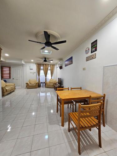 a living room with a table and a ceiling fan at Sapphire Residence in Jenjarum