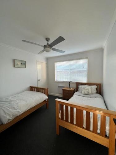 a bedroom with two beds and a ceiling fan at Sinclair Surfside Stay in Surf Beach