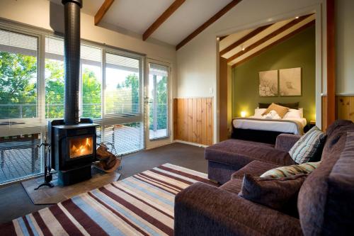 a living room with a fireplace and a bedroom at Eastern View Studio in Daylesford