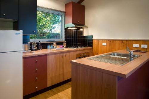 a kitchen with a sink and a refrigerator at Eastern View Studio in Daylesford