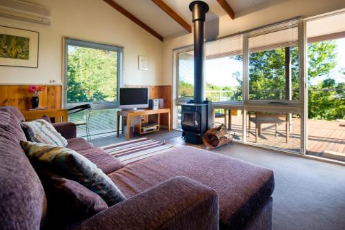 a living room with a couch and a fireplace at Eastern View Studio in Daylesford