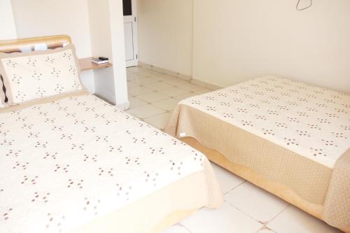 a room with two beds and a table at Hotel Top Five in Kampala