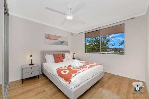 Un dormitorio con una cama grande y una ventana en KozyGuru / Clovelly / 2B Kozy APT / NCL037, en Sídney