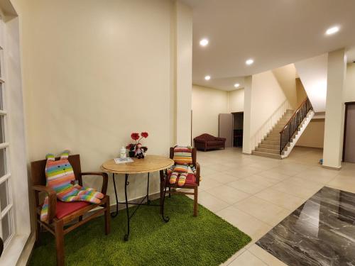 a room with a table and chairs and a staircase at Fathers Guesthouse Age 7 years old and above only in Tanah Rata