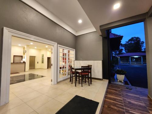a kitchen and dining room with a table and chairs at Fathers Guesthouse Age 7 years old and above only in Tanah Rata