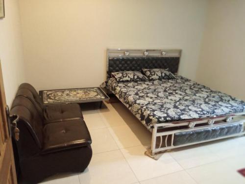 1 dormitorio con 1 cama y 1 silla en N N Guests Palace, en Islamabad