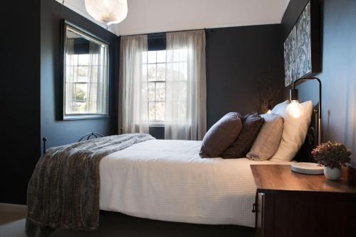 a bedroom with a large bed and two windows at Ebony Twigg in Hepburn Springs