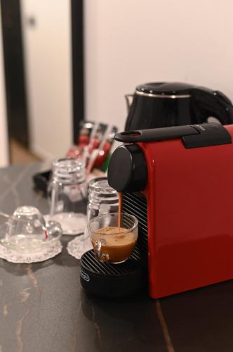 a red toaster sitting on a table with a cup of coffee at Selfie's Boutique Hotel in Tiberias