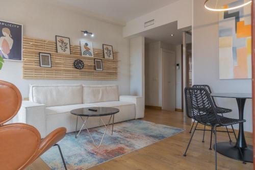a living room with a couch and a table and chairs at Aparthotel ARDMADRID Centro in Madrid