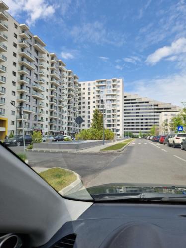 un coche aparcado en una calle con grandes edificios en Onix - Nordic Studio Apartment 3, Premium Parking en Bucarest