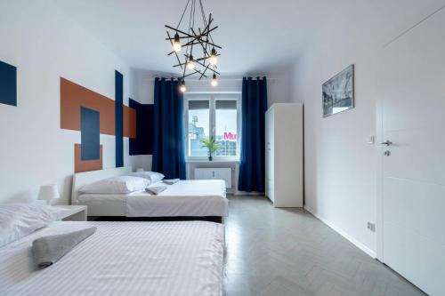 1 dormitorio con 2 camas y lámpara de araña en Blue Apartment Browar Central, en Poznan