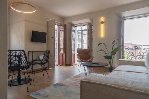 sala de estar con sofá, mesa y sillas en Aparthotel ARDMADRID Centro, en Madrid