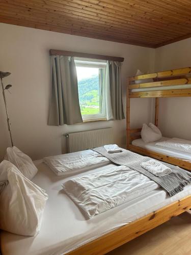 een slaapkamer met 2 stapelbedden en een raam bij Haus Stille Oase Top 3 in Bruck an der Großglocknerstraße