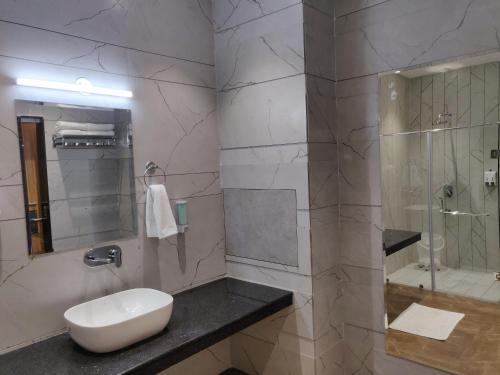 a bathroom with a sink and a glass shower at Hotel Luxurio by Shree Hari Hotels in Amritsar