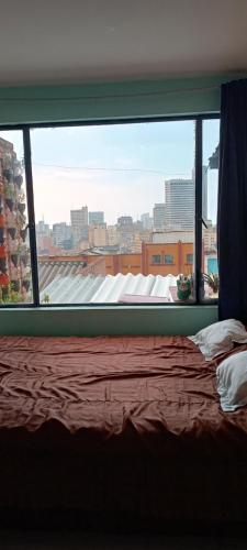 a bedroom with a window with a view of a city at Casa 2600 in Bogotá