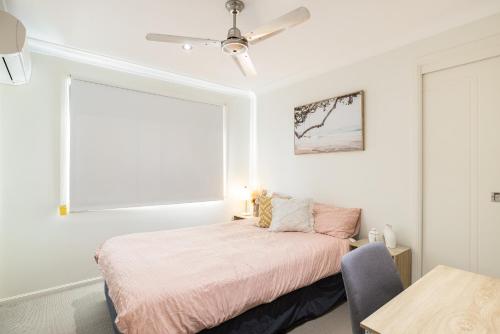 a white bedroom with a bed and a window at Great Location! Close to Restaurants & Train! in Brisbane