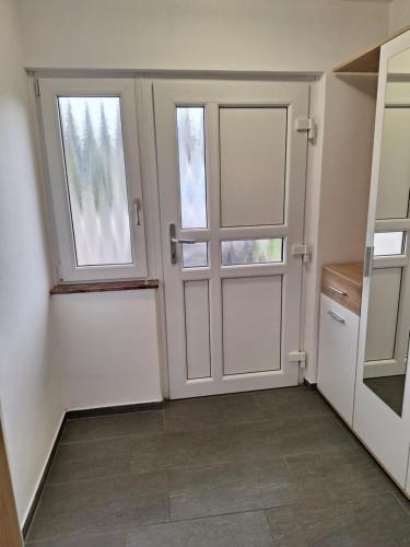 a room with a door and two windows at Guesthouse Flower in Ljubljana