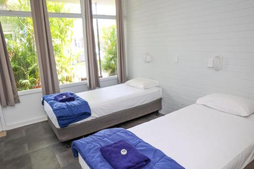 2 Betten in einem Zimmer mit 2 Fenstern in der Unterkunft Park Beach Hotel Motel in Coffs Harbour