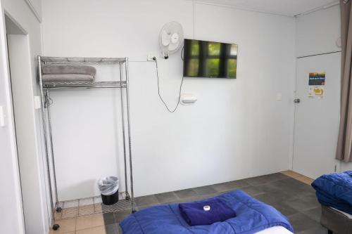 a room with a shower and a blue bed at Park Beach Hotel Motel in Coffs Harbour