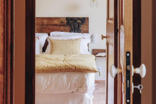 a bedroom with a bed with white sheets and pillows at Residence CASE DI PI GNA, deux magnifiques villas indépendantes avec piscines individuelles , proches de la plage d'Algajola in Algajola