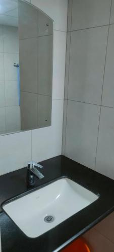 a bathroom with a sink and a mirror at Luxurious Apartment with a pool and gym near Trivandrum railway station in Trivandrum