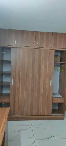 a wooden cabinet with shelves in a room at Luxurious Apartment with a pool and gym near Trivandrum railway station in Trivandrum