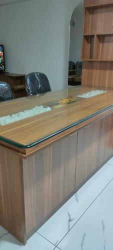 a wooden counter with a mirror on top of it at Luxurious Apartment with a pool and gym near Trivandrum railway station in Trivandrum