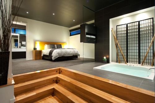 1 dormitorio con 1 cama y bañera en una habitación en Elira 1 en Daylesford