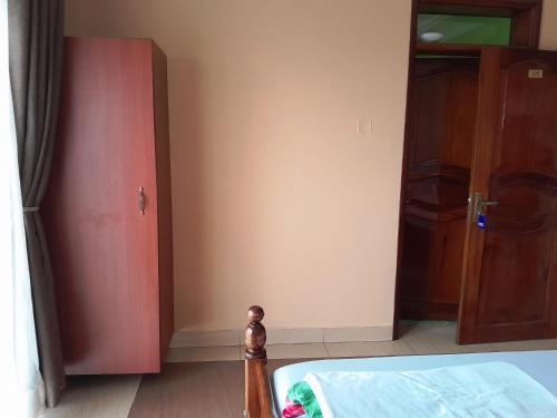 a bedroom with a bed and a red cabinet at Olina Hotel and Apartments Kampala in Kampala