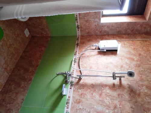 a shower in a bathroom with a green wall at Olina Hotel and Apartments Kampala in Kampala