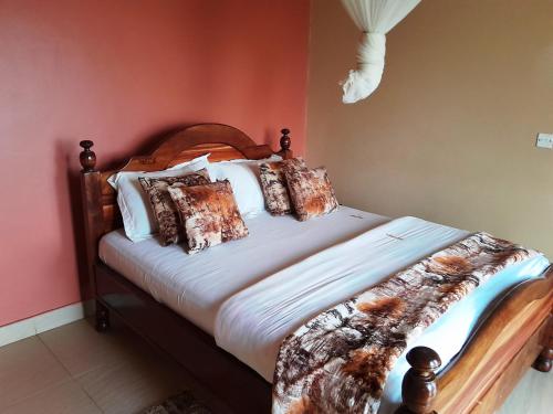 a bedroom with a large bed with white sheets and pillows at Olina Hotel and Apartments Kampala in Kampala